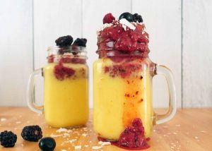 Mango smoothie with tart triple berry topping by Roaring Spork