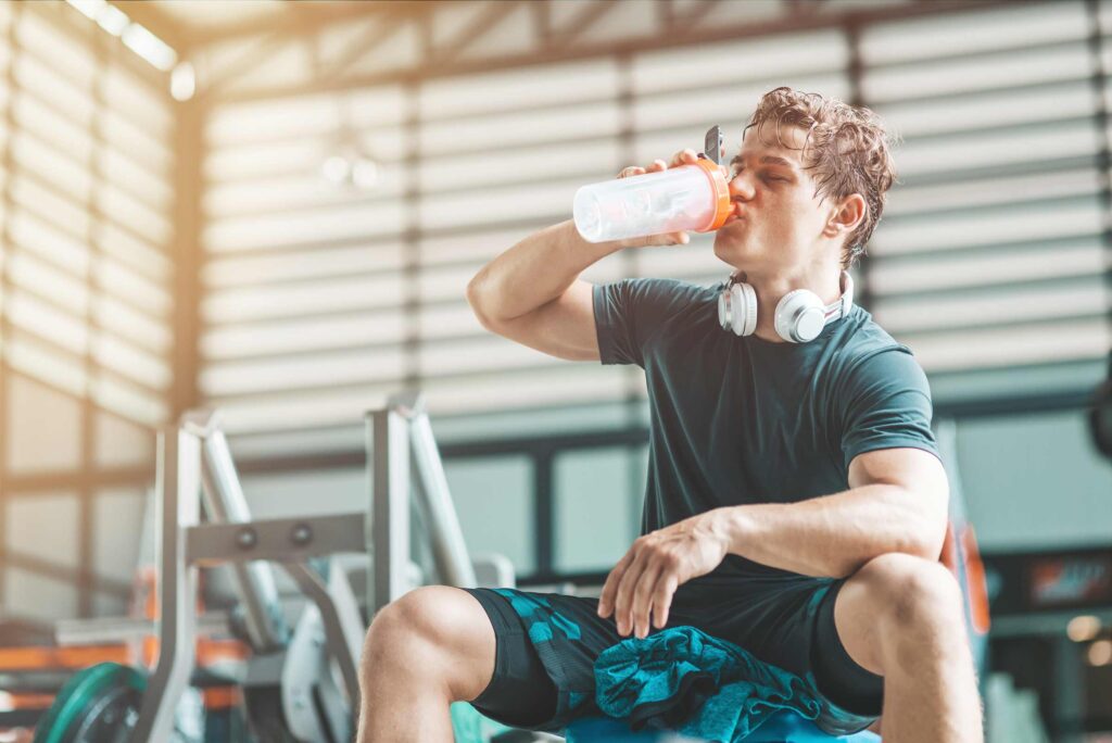 Guy drinking a vegan pre workout at the gym